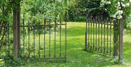 Einladung, in den Garten einzutreten: Malerischer Garten mit schmiedeeisernem, offenem Tor